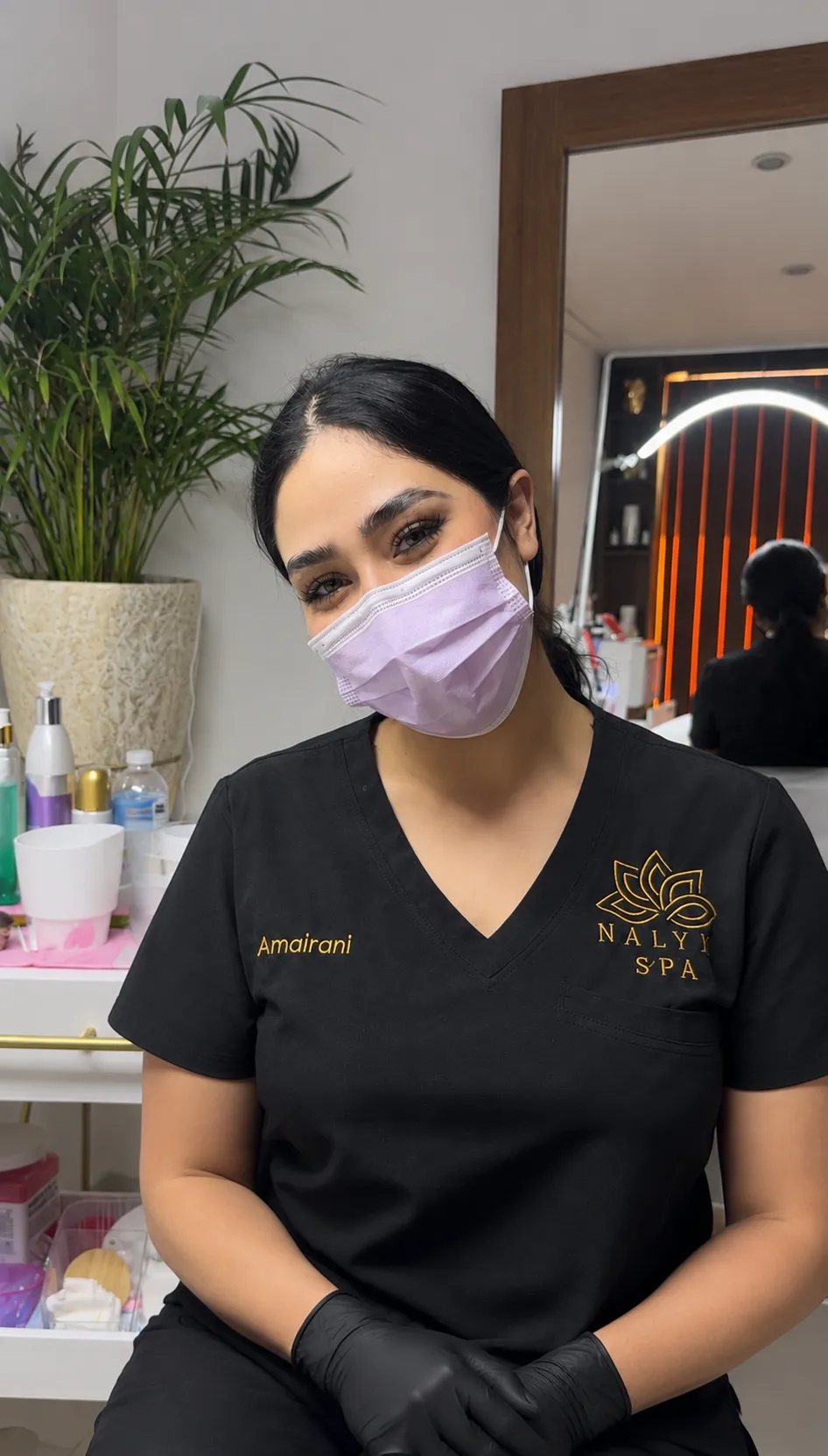 Cosmetóloga de Nalyjo Spa con cubrebocas y uniforme institucional