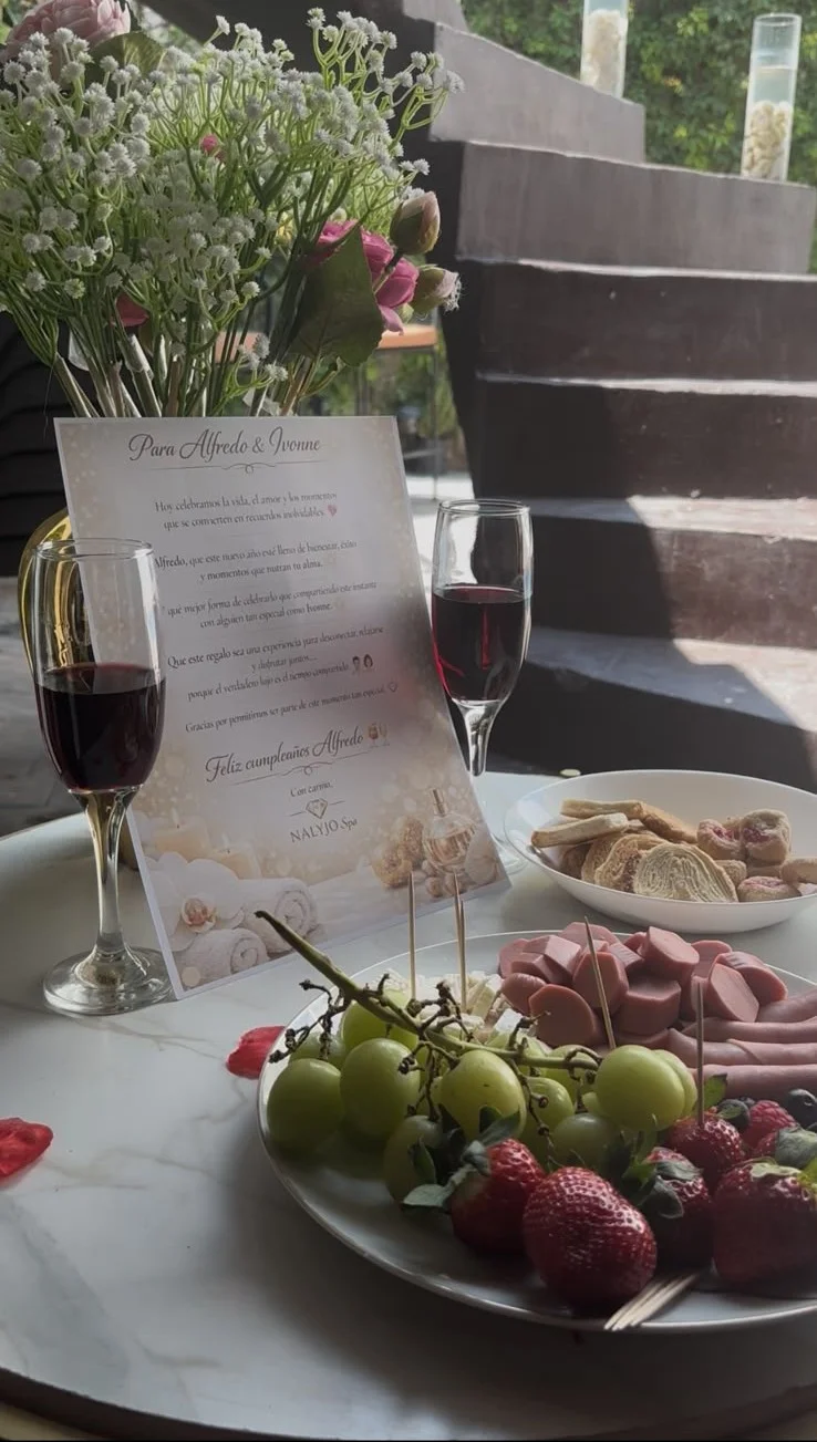 Mesa con frutos, vino y detalles románticos para experiencia de spa